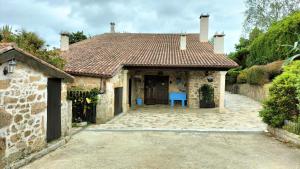圣徐连代萨利斯As Seis Chemineas的房屋设有瓷砖屋顶和蓝色椅子