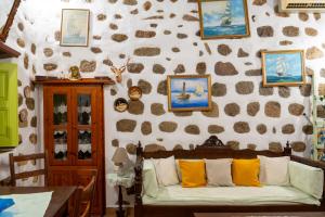 帕特莫斯Vintage White House Patmos的客厅配有沙发和带照片的墙壁