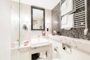 斯德哥尔摩空斯特拉德花园酒店的白色的浴室设有水槽和镜子