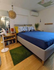 蒙法尔科内appartamento centro storico的一间卧室配有蓝色的床和绿色地毯