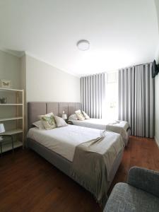 波尔图Sonetos - Guest House的一间卧室设有两张床和窗户。