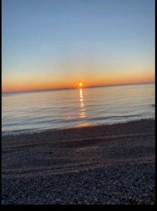 勒阿弗尔Plage du Havre的海滩上的日落,日落在水面上