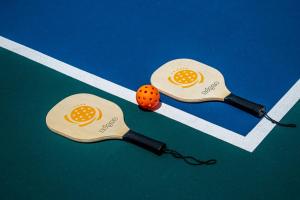 普拉亚卡门Platinum Yucatan Princess Adults Only - All Inclusive的两把乒乓球桨,在球场上放一个橙球