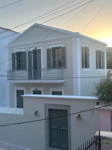 锡米Nisomar Suites的白色的房子,设有绿门和阳台