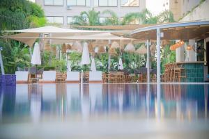 利马索尔Odysseia Hotel Kapetanios的一座大楼内带椅子和遮阳伞的游泳池