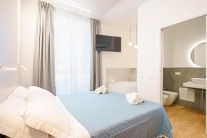 卡利亚里Aqua Comfort Rooms - Eja Sardinia的一间卧室配有一张床、一个浴缸和一个水槽