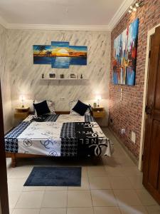 洛美Holiday Appartment Elbe的一间卧室设有一张床和砖墙