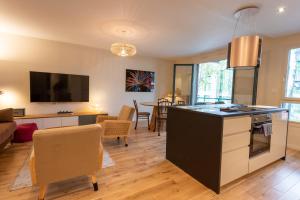 维勒班LuxeZen - SPA的厨房以及带桌椅的起居室。