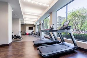 华盛顿首都希尔顿酒店的一个带跑步机和椭圆机的健身房,位于带窗户的房间内
