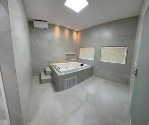 马瑙斯River X House的白色的浴室设有浴缸和水槽。
