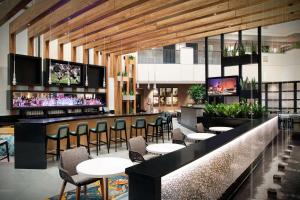 奥兰多奥兰多-机场希尔顿合博套房酒店的餐厅设有酒吧,配有桌椅