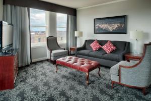 波特兰Embassy Suites by Hilton Portland Downtown的客厅配有沙发、椅子和电视