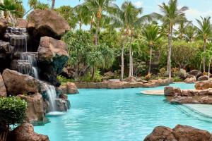 维雷亚Ho'olei at Grand Wailea的棕榈树度假村内带瀑布的游泳池