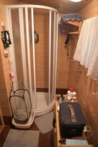 Ostoja dom letniskowy的带淋浴和手提箱的小浴室