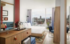 都柏林Hampton By Hilton Dublin City Centre的酒店客房设有一张床和一个大窗户