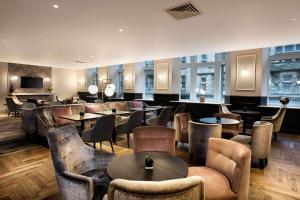 爱丁堡希尔顿爱丁堡卡尔顿酒店的一间带桌椅的餐厅和一间酒吧