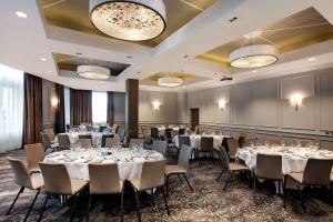 爱丁堡希尔顿爱丁堡卡尔顿酒店的宴会厅配有桌椅和灯具