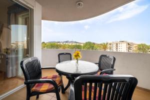 卡拉费尔Beach apartment Calafell center with parking的阳台配有桌椅和窗户。