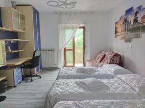 San BartolomeoCamera mezzo montagna的一间卧室设有两张床、一张桌子和一个窗口。