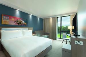 汉密尔顿Hampton By Hilton Hamilton Park的酒店客房配有一张床、一张书桌和一台电视。