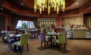 坎伯诺尔德韦斯特伍德高尔夫度假酒店——Q酒店的一间带桌椅和吊灯的餐厅