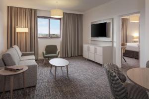 坎伯诺尔德韦斯特伍德高尔夫度假酒店——Q酒店的一间配备有沙发及电视的酒店客房