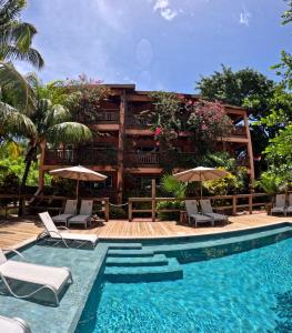 西湾Hotel Posada Seremein Roatan的一个带椅子和遮阳伞的游泳池的度假酒店