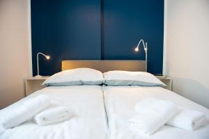 格涅兹诺Apartamenty Emilia的一张带白色床单和枕头的床