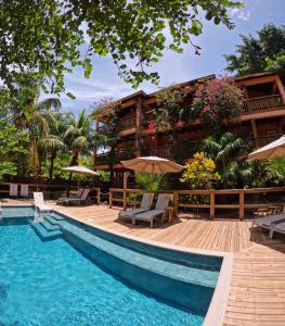 西湾Hotel Posada Seremein Roatan的一个带游泳池、椅子和遮阳伞的度假村