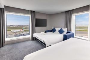 希灵登Hilton Garden Inn London Heathrow Terminal 2 and 3的酒店客房设有两张床和大窗户。