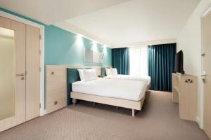 伦敦汉普顿希尔顿酒店 的卧室配有一张白色大床和电视。
