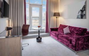 伦敦希尔顿伦敦伊斯灵顿天使酒店的客厅配有紫色沙发和桌子