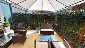 伦敦DoubleTree by Hilton London Angel Kings Cross的一个带桌椅的庭院和绿色的墙壁