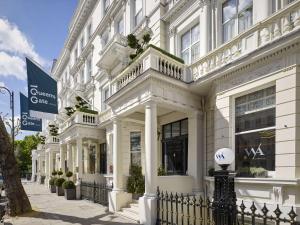 伦敦100 Queen’s Gate Hotel London, Curio Collection by Hilton的一座白色的建筑,围栏上有一个球