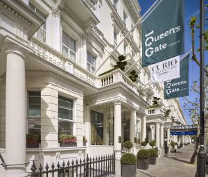 伦敦100 Queen’s Gate Hotel London, Curio Collection by Hilton的前面有标志的白色建筑