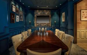 伦敦100 Queen’s Gate Hotel London, Curio Collection by Hilton的一间设有木桌和蓝色墙壁的用餐室