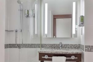 科比希尔顿科比汉密尔顿酒店的浴室配有盥洗盆和带镜子的淋浴