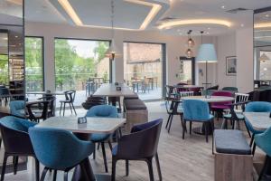 约克Hampton by Hilton York Piccadilly的餐厅设有桌椅和窗户。