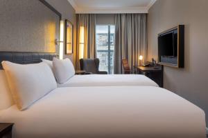 爱丁堡爱丁堡市中心希尔顿逸林酒店的酒店客房设有一张白色大床和一台电视。