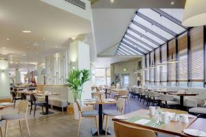 霍尔DoubleTree by Hilton Manchester Airport的用餐室设有桌椅和窗户。