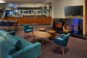 霍尔DoubleTree by Hilton Manchester Airport的一个带沙发和椅子的大堂和一间酒吧