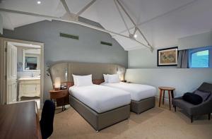 利物浦利物浦希尔顿逸林酒店的一间卧室配有一张床、一张桌子和一把椅子