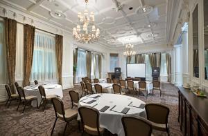 利物浦利物浦希尔顿逸林酒店的一间会议室,配有桌椅和屏幕