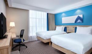 格拉斯哥格拉斯哥市中心希尔顿汉普顿酒店的一间酒店客房,设有两张床和电视