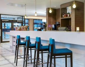 格拉斯哥格拉斯哥市中心希尔顿汉普顿酒店的厨房设有蓝椅酒吧