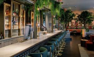 伦敦特拉法加圣詹姆斯，伦敦希尔顿Curio Collection酒店的餐厅内的酒吧,带蓝色椅子