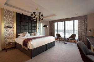 北昆斯费里爱丁堡希尔顿逸林酒店 - 昆斯费里路口的一间卧室配有一张大床和一张桌子及椅子