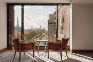 海牙海牙希尔顿酒店的客房设有桌椅和大窗户。