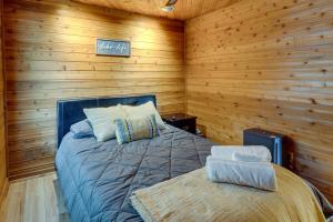 奥康诺摩沃Okauchee Lake Vacation Rental with Boat Dock!的卧室配有木墙内的一张床
