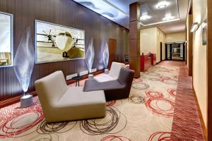美因河畔法兰克福希尔顿法兰克福机场酒店的酒店大堂设有两把椅子和一张桌子
